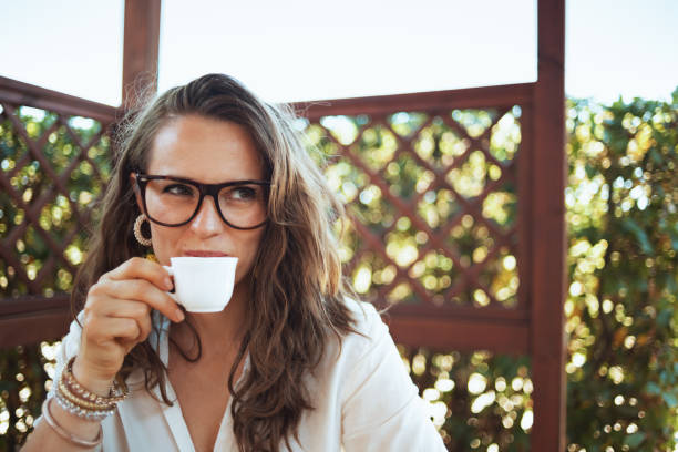 istock happy woman in white shirt drinking coffee 1297608121