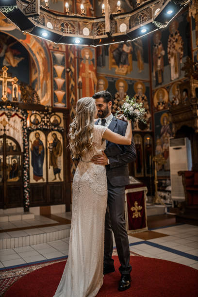 istock Smiling couple standing in church face to face while embracing each other 1297608432