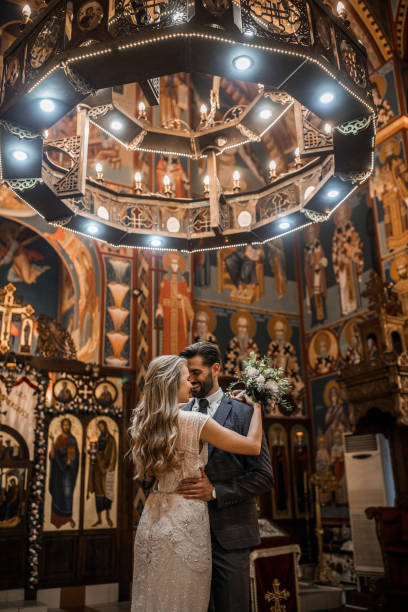 istock Smiling couple standing in church face to face while embracing each other 1297608433
