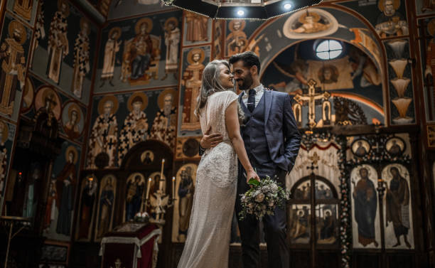 Smiling couple standing in church face to face while embracing each other