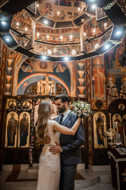 istock Smiling couple standing in church face to face while embracing each other 1297608441