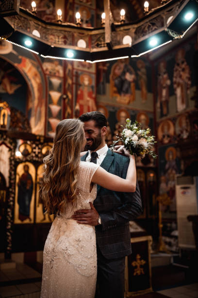 istock Smiling couple standing in church face to face while embracing each other 1297608449