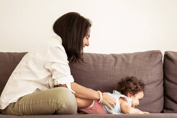 istock Happy black haired mom cuddling cute baby 1297609184
