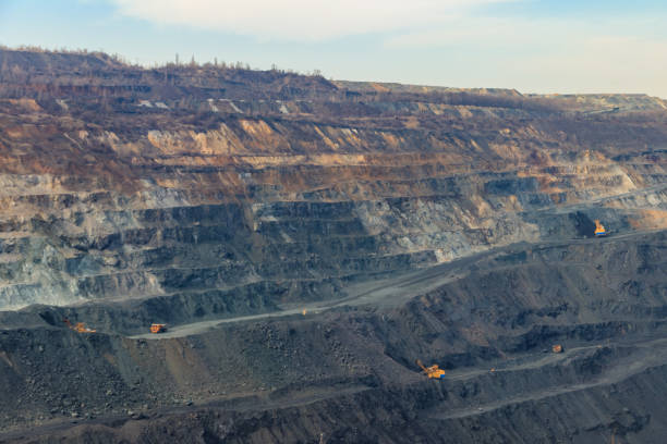 istock Huge iron ore quarry with working dump trucks and excavators 1297609820