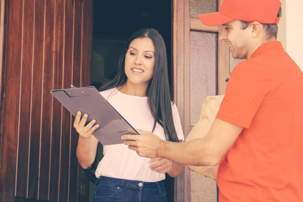 istock Happy courier showing order sheet to client 1297611453