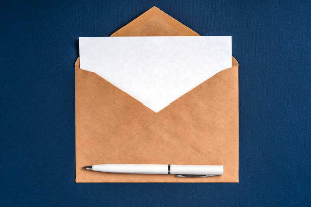 istock An envelope with a white sheet of paper on a dark blue background and a white pen. Concise, minimalist background 1297611740