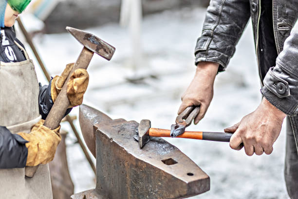istock A blacksmith man and his son forge a horseshoe on an anvil. 1297611742