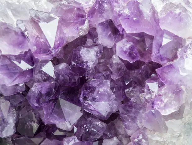 Photo of Close up view of large violet amethyst crystal cluster. Esoteric magical background concept.