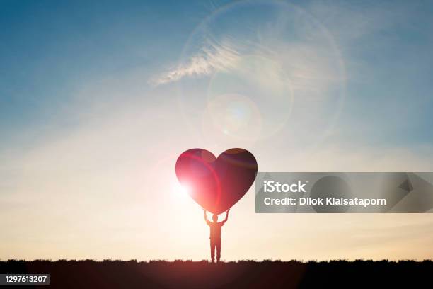 Silhouette Man Show Two Hand Rise Up And Carrying Heart With Sunlight And Blue Sky Valentine S Day Concept Stock Photo - Download Image Now
