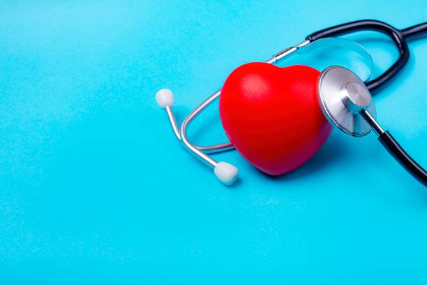 Red heart and stethoscope on blue background. Still life, medica stock photo