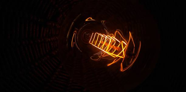 istock Light Bulb filament glows in dark Orange colour at night 1297614438