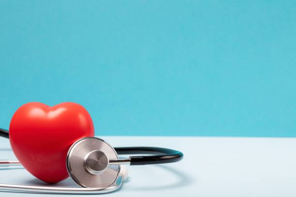 Red heart and stethoscope on blue background. Still life, medica stock photo