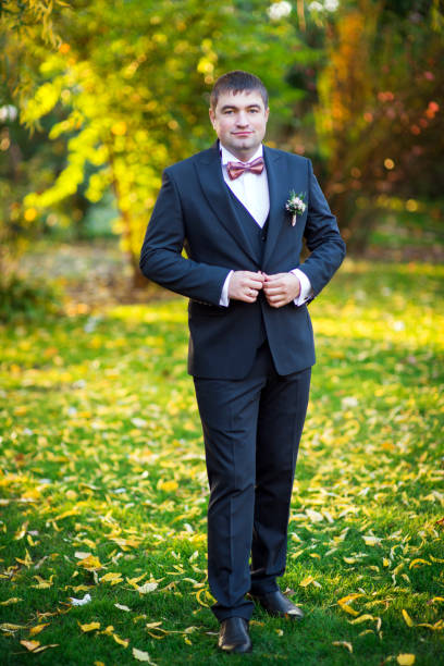 istock The groom in a suit buttons up the buttons 1297616344