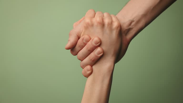 help friend through a tough time. rescue gesture. hands reaching together on green background