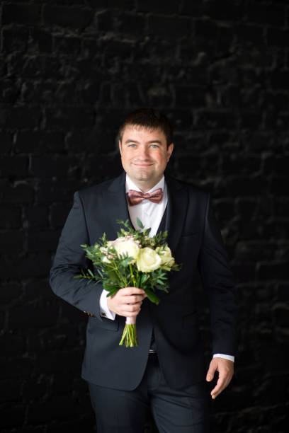 istock Groom in a suit holds a wedding bouquet 1297616806