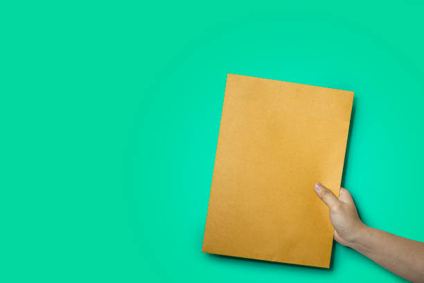 Close up of hand holding a brown envelope.