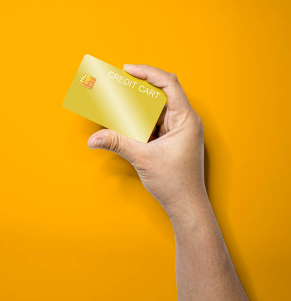 istock The person's hand holds a gold credit card with one hand. 1297618270