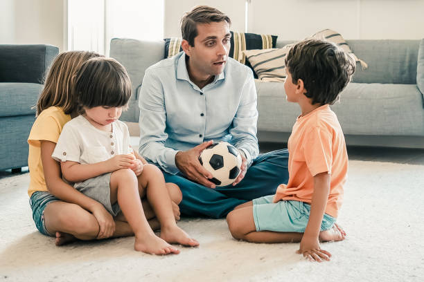 istock Caucasian dad holding ball and talking with children 1297618951