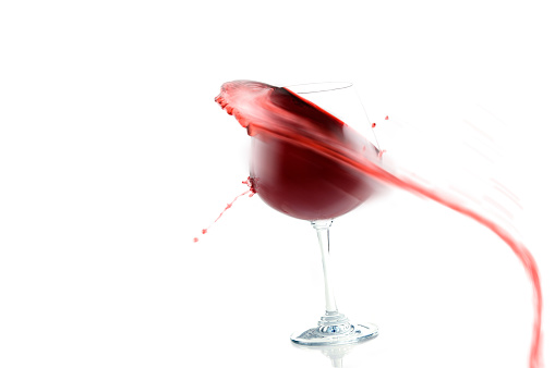 Red wine splashing in wineglass