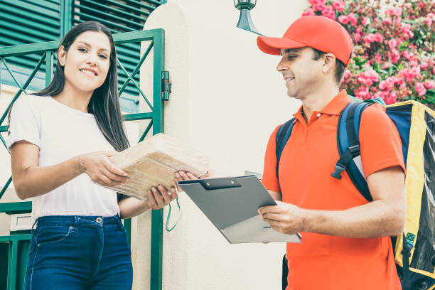 istock Brunette woman accepting package from professional deliveryman 1297619284