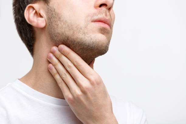 man suffering from throat problems, lymph glands Close up of sick man suffering from throat problems, grey background, isolated. Lymph glands, painful swallowing, pharyngitis, laryngeal swelling concept. Inflammation of the upper respiratory tract larynx stock pictures, royalty-free photos & images