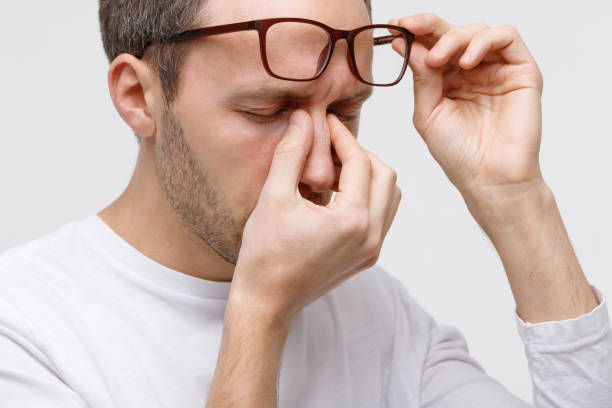 istock man in eyeglasses rubbing nose bridge, feels tired 1297619373