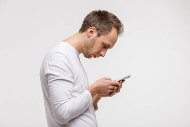 man looking and using smart phone with scoliosis, Incorrect posture Close up portrait of man looking and using smart phone with scoliosis, side view, isolated on gray background. Rachiocampsis, kyphosis curvature of neck, Incorrect posture,
orthopedics concept neck stock pictures, royalty-free photos & images