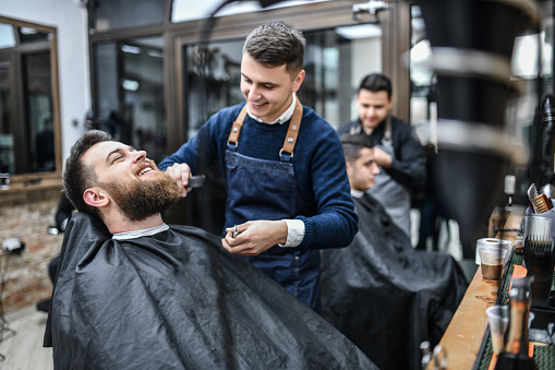 Smiling Barber Combing Customer's Haircut