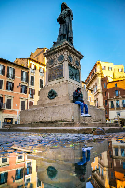 ジョルダーノ・ブルーノの像は、ローマのカンポ・デ・フィオーリ広場の水たまりに反映されています - puddle rome reflection street ストックフォトと画像