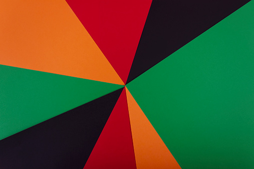 Red, yellow and green color paper on the black background. Black History Month concept. Flat lay. Copy space.
