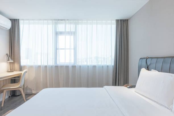 istock Warm clean bedroom with white sheets and white pillows 1297624151