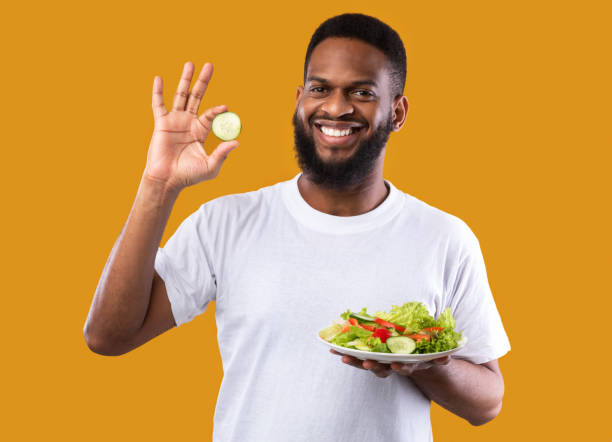 istock Black Guy Posing With Healthy Salad Gesturing Okay, Yellow Background 1297624220