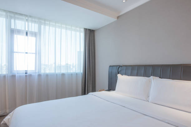 istock Warm clean bedroom with white sheets and white pillows 1297624225