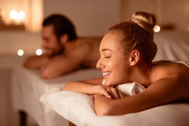 ehepartner erhalten entspannende schönheitsbehandlung liegend im luxury spa center - wellness stock-fotos und bilder