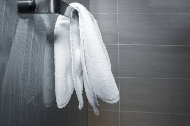 A clean white towel hanging in the bathroom