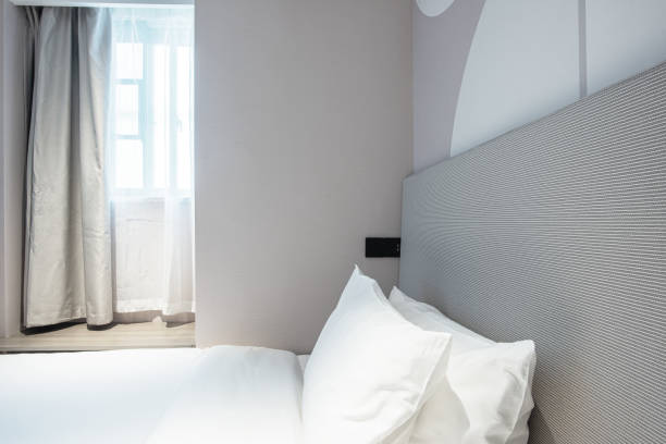 istock Warm clean bedroom with white sheets and white pillows 1297624781