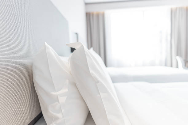 istock Warm clean bedroom with white sheets and white pillows 1297624853