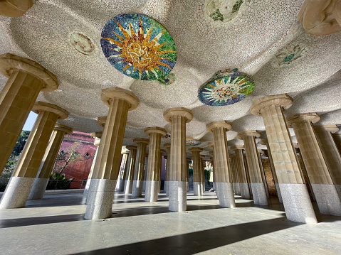 Under the stunning Park Guell in Barcelona with colorful mosaic and columns. Catalonia, Spain