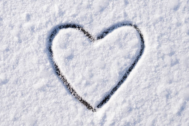 istock Heart on snow drawn with an index finger 1297627377