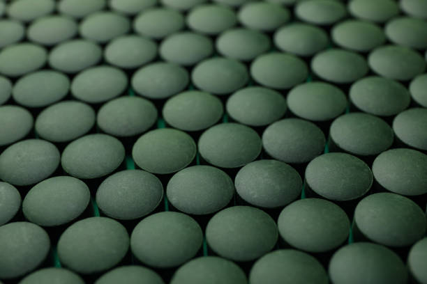 green pills,Spirulina tablets on black Stone plate.