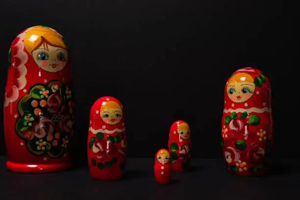 Set of five matryoshka russian nesting dolls with black background.