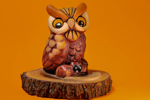 istock Small handmade ceramic owl with orange background. Small handmade ceramic owl with orange background. Writing space 1297628694