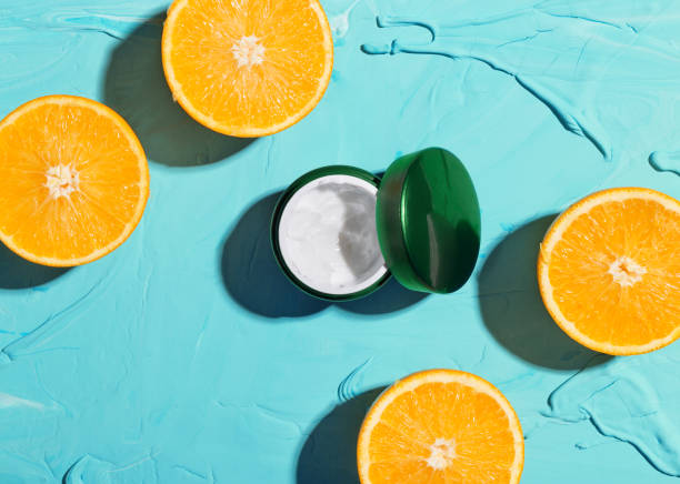 istock Cosmetic moisturizing face cream with vitamin C. Oranges and jars with cream on a blue background top view 1297629145