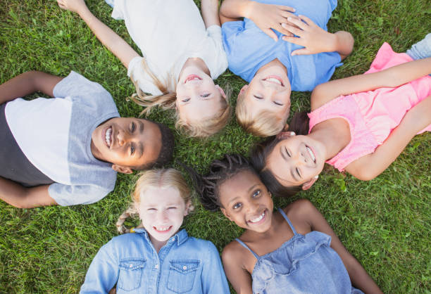 istock Overhead view of children lying on grass 1297630432
