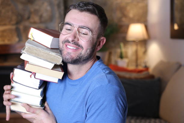 istock Man holding heavy pile of books 1297630608