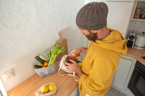 istock Man puts away vegetable groceries in the kitchen 1297630638
