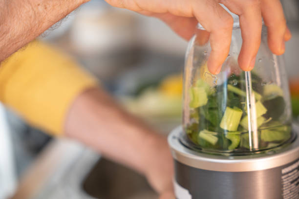 istock Man makes a green healthy smoothie in the kitchen 1297631696