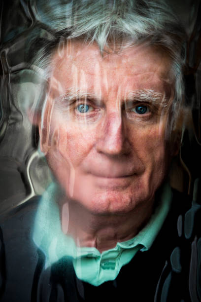 istock Depressed senior man looking out of window 1297631726
