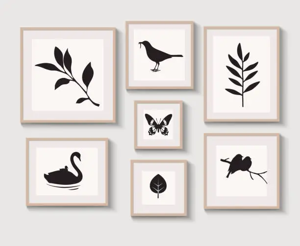 Vector illustration of Set of light braun wood frames with shadow on gray wall for interior design. Collection of decorative bird, stems, leaf, butterfly silhouette.