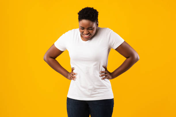 istock Overweight Black Woman Having Stomachache Standing Over Yellow Studio Background 1297634474